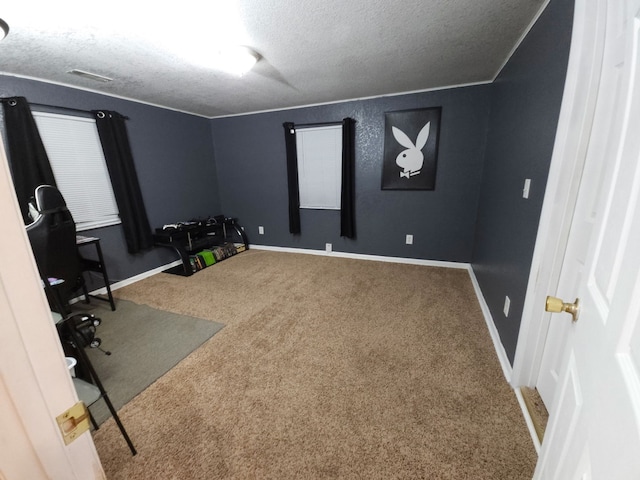 unfurnished office featuring visible vents, baseboards, a textured ceiling, and carpet flooring