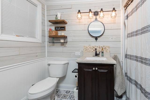 bathroom featuring a shower with curtain, toilet, wood walls, and vanity