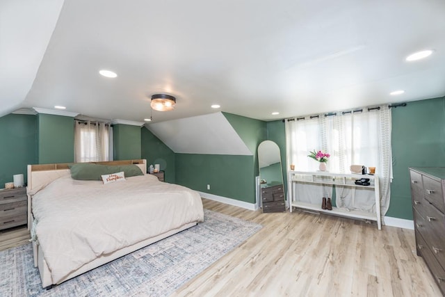 bedroom with lofted ceiling, baseboards, and wood finished floors