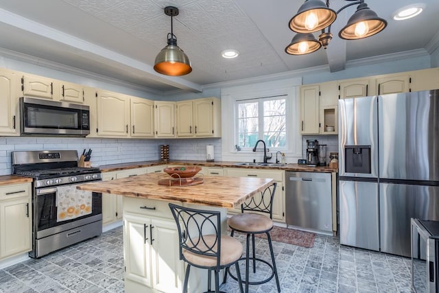 kitchen with a sink, stainless steel appliances, and wood counters