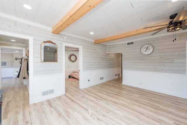 spare room with visible vents, wood finished floors, beamed ceiling, and ceiling fan