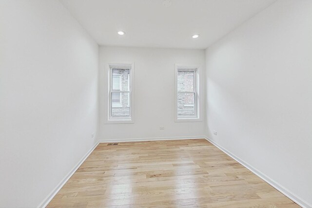 empty room featuring recessed lighting, baseboards, and light wood-style floors