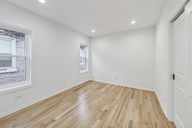 empty room with recessed lighting, light wood-style flooring, and baseboards