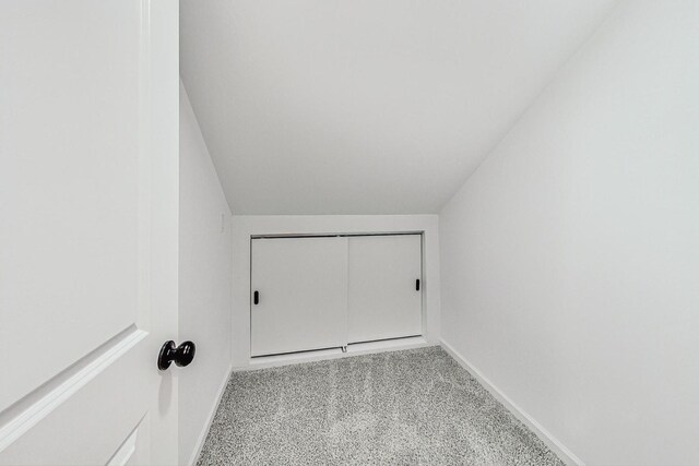 interior space featuring baseboards, lofted ceiling, and carpet floors