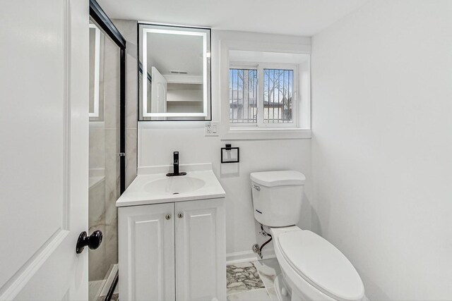 bathroom with vanity, toilet, baseboards, and marble finish floor