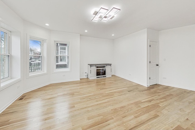 unfurnished living room featuring recessed lighting, light wood-style floors, visible vents, and baseboards