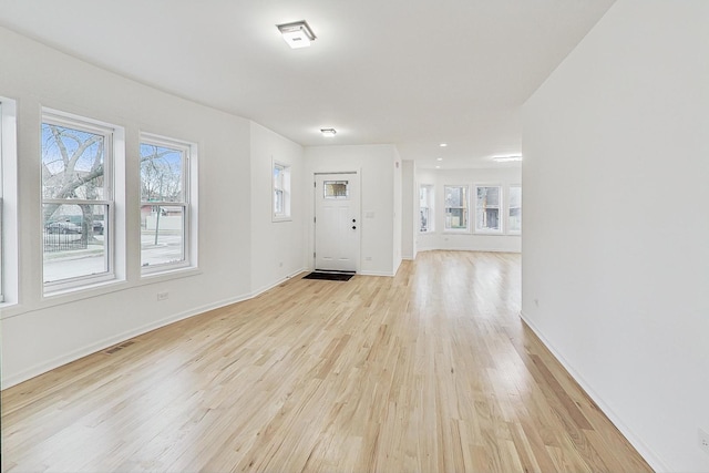 foyer featuring visible vents, baseboards, and light wood-style floors