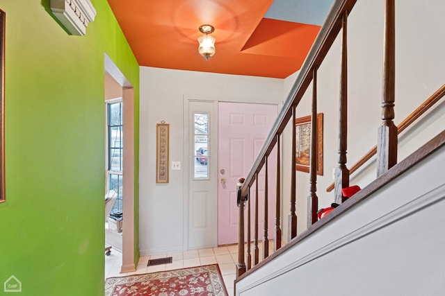 foyer with tile patterned flooring, visible vents, stairs, and baseboards