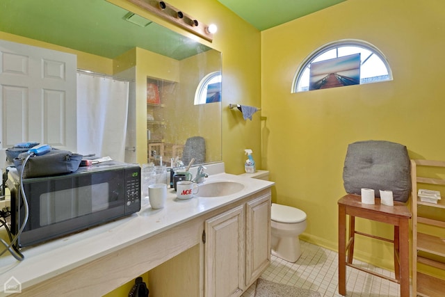 bathroom featuring vanity, a shower with shower curtain, baseboards, tile patterned flooring, and toilet