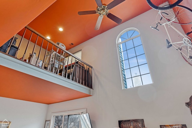 interior space featuring a wealth of natural light, visible vents, a high ceiling, and a ceiling fan