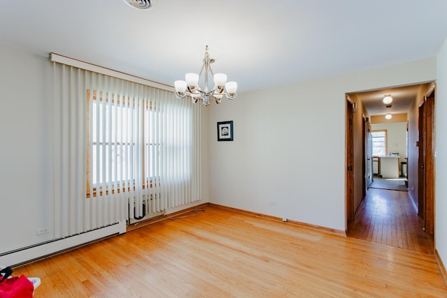 unfurnished room featuring light wood-style flooring, baseboards, baseboard heating, and a chandelier