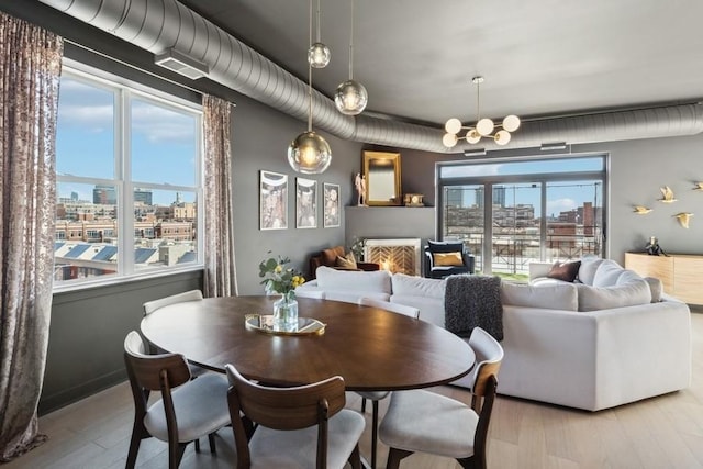 dining room featuring a chandelier, a city view, and wood finished floors