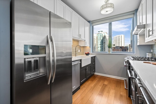 kitchen with tasteful backsplash, a city view, range hood, and appliances with stainless steel finishes