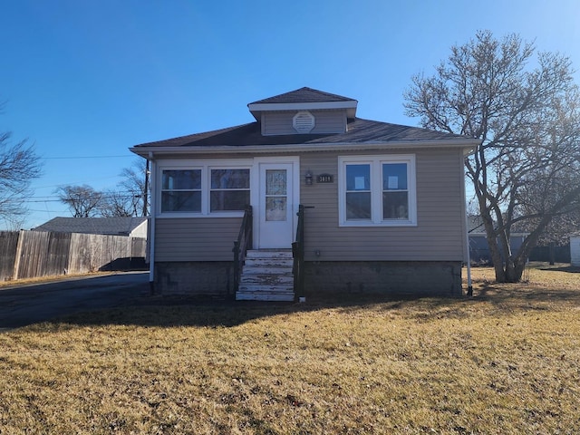 bungalow featuring entry steps, a front yard, and fence