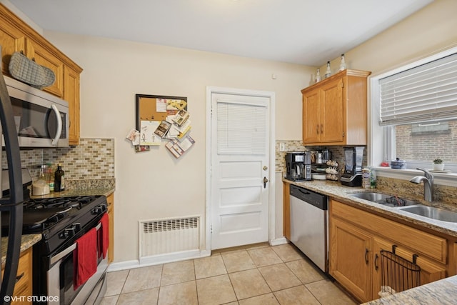 kitchen with visible vents, light stone countertops, light tile patterned floors, appliances with stainless steel finishes, and a sink