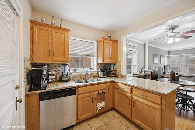 kitchen featuring a wealth of natural light, a sink, a peninsula, and stainless steel dishwasher