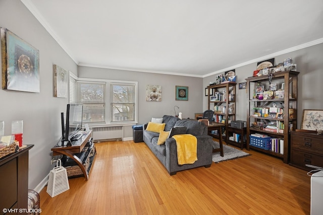 living area with radiator, wood finished floors, baseboards, and ornamental molding