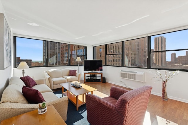 living room with baseboards, wood finished floors, and a wall mounted AC