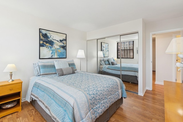 bedroom featuring wood finished floors, a closet, and baseboards