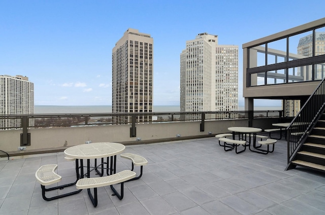 view of patio / terrace featuring a view of city and stairs