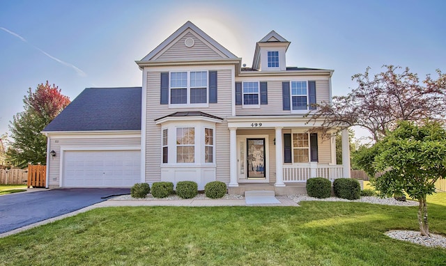 traditional home featuring a front lawn, fence, aphalt driveway, a porch, and a garage