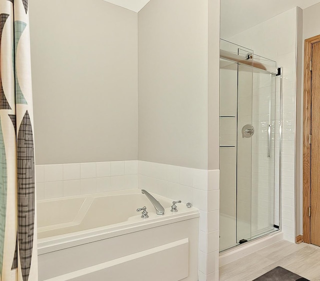 bathroom featuring a garden tub and a stall shower