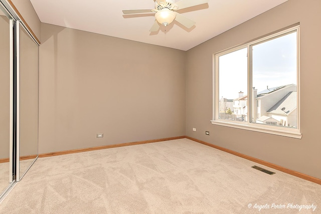 unfurnished bedroom with visible vents, light carpet, baseboards, and a closet