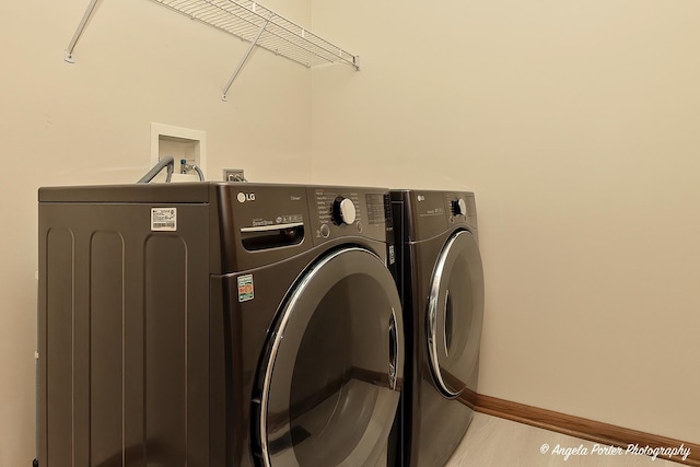 clothes washing area with laundry area, baseboards, and independent washer and dryer