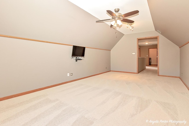 bonus room featuring baseboards, light colored carpet, ceiling fan, and vaulted ceiling