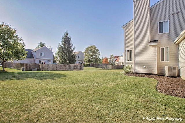 view of yard featuring central air condition unit and fence