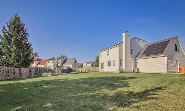 view of yard with a residential view, central air condition unit, and a fenced backyard