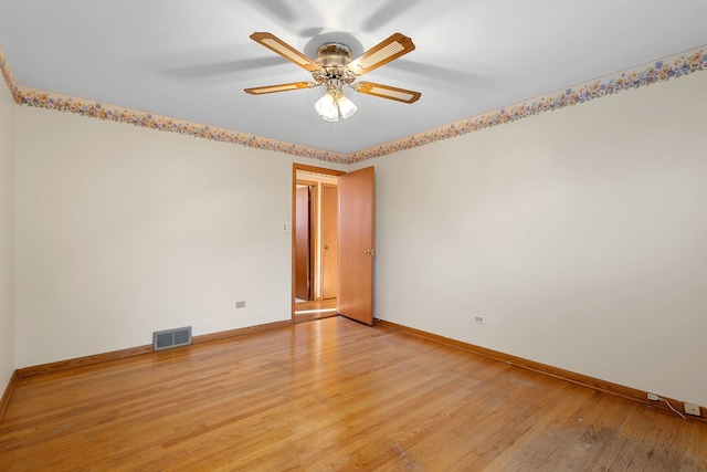 empty room with a ceiling fan, baseboards, visible vents, and light wood finished floors