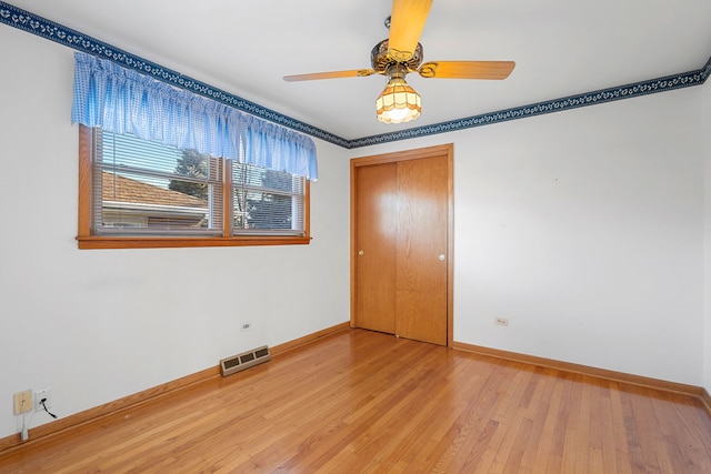 unfurnished bedroom featuring a closet, visible vents, light wood-type flooring, and baseboards