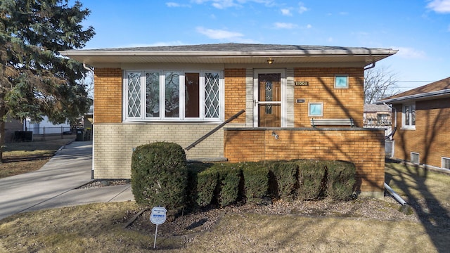 view of front of property featuring brick siding and fence