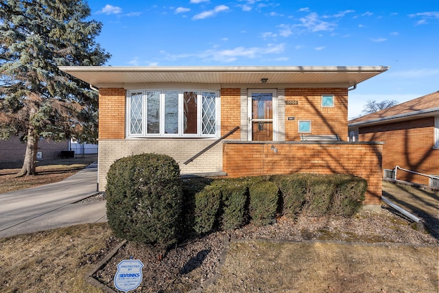 view of front of house featuring brick siding and fence