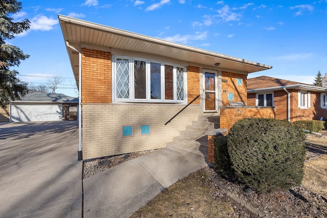 view of front of house featuring an outbuilding, brick siding, and a detached garage