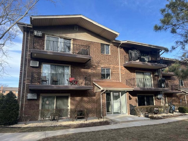 view of front of property featuring brick siding and a balcony