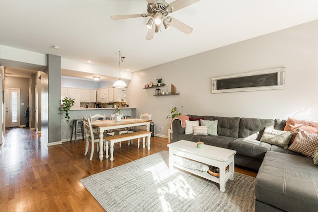 living room with a ceiling fan, wood finished floors, and baseboards