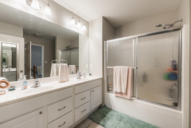 bathroom with a sink, visible vents, enclosed tub / shower combo, and double vanity