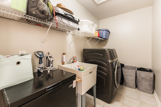 laundry room with laundry area, light tile patterned floors, and separate washer and dryer