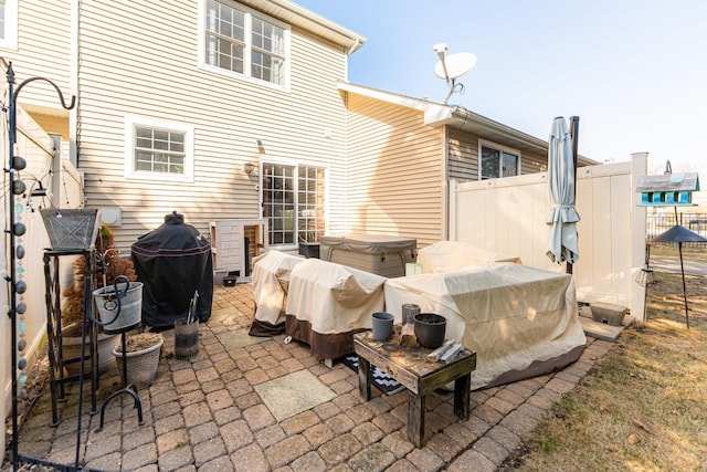 rear view of house featuring a patio area, a hot tub, and fence