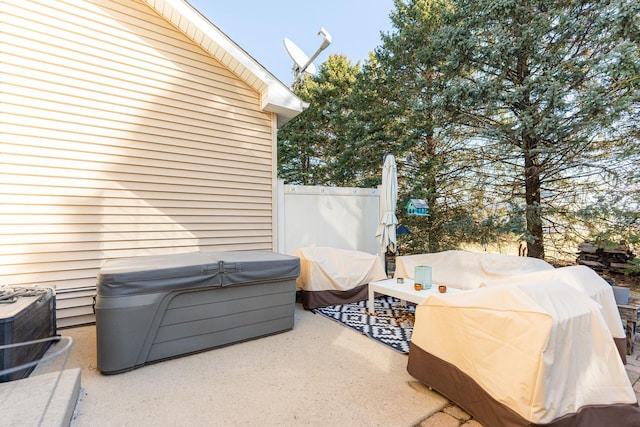 view of patio / terrace featuring a hot tub and fence