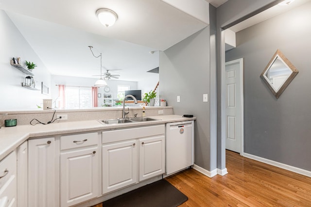 kitchen with a ceiling fan, white dishwasher, a sink, white cabinets, and light wood-style floors