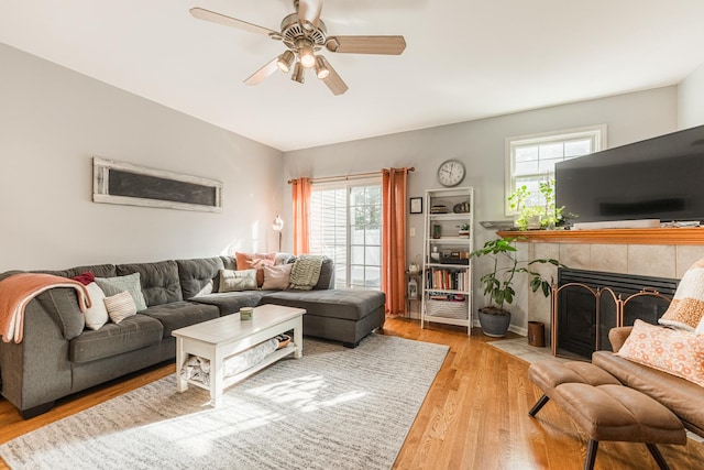 living room with a ceiling fan, wood finished floors, and a fireplace