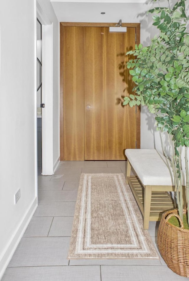 interior space featuring baseboards and light tile patterned flooring