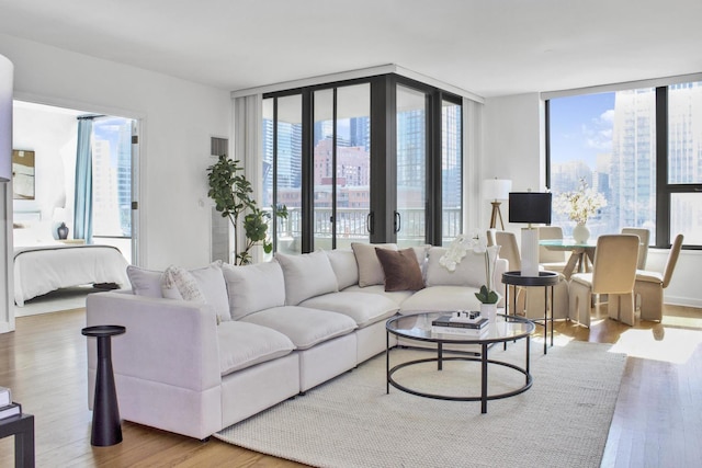 living area featuring a city view, wood finished floors, and floor to ceiling windows