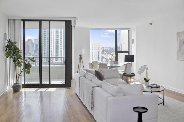 living room with expansive windows, a view of city, plenty of natural light, and wood finished floors