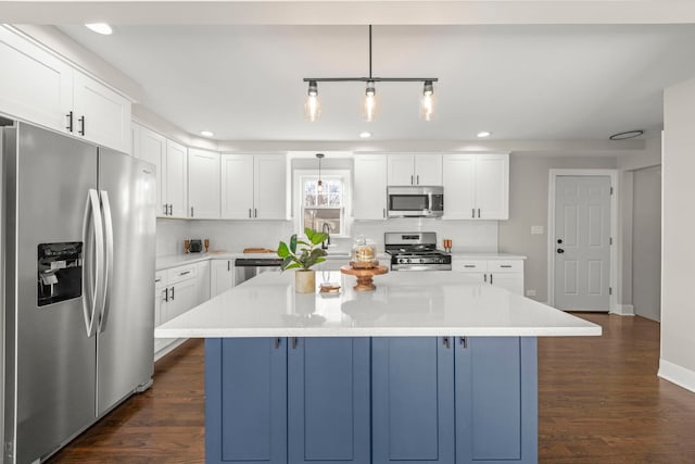 kitchen featuring a kitchen island, dark wood-type flooring, appliances with stainless steel finishes, and light countertops