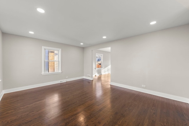 spare room with recessed lighting, dark wood-style floors, visible vents, and baseboards