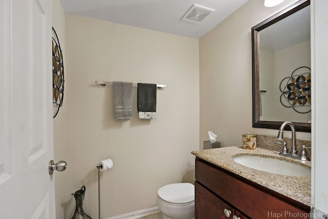 half bathroom featuring visible vents, baseboards, toilet, and vanity